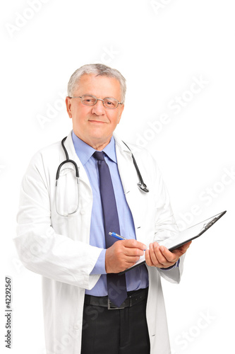 A mature healthcare professional holding a clipboard and posing