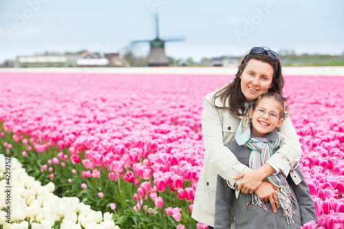 Girl with mother in the purple tulips field