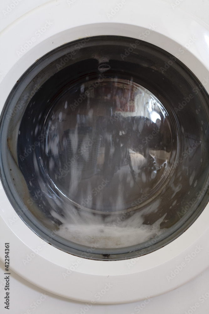 View of washing man drum spinning round on a wash cycle View of washing man drum spinning round on a wash cycle