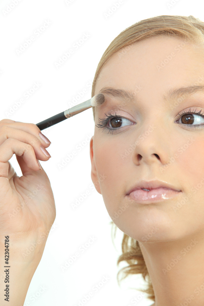 Young woman applying eyeshadow