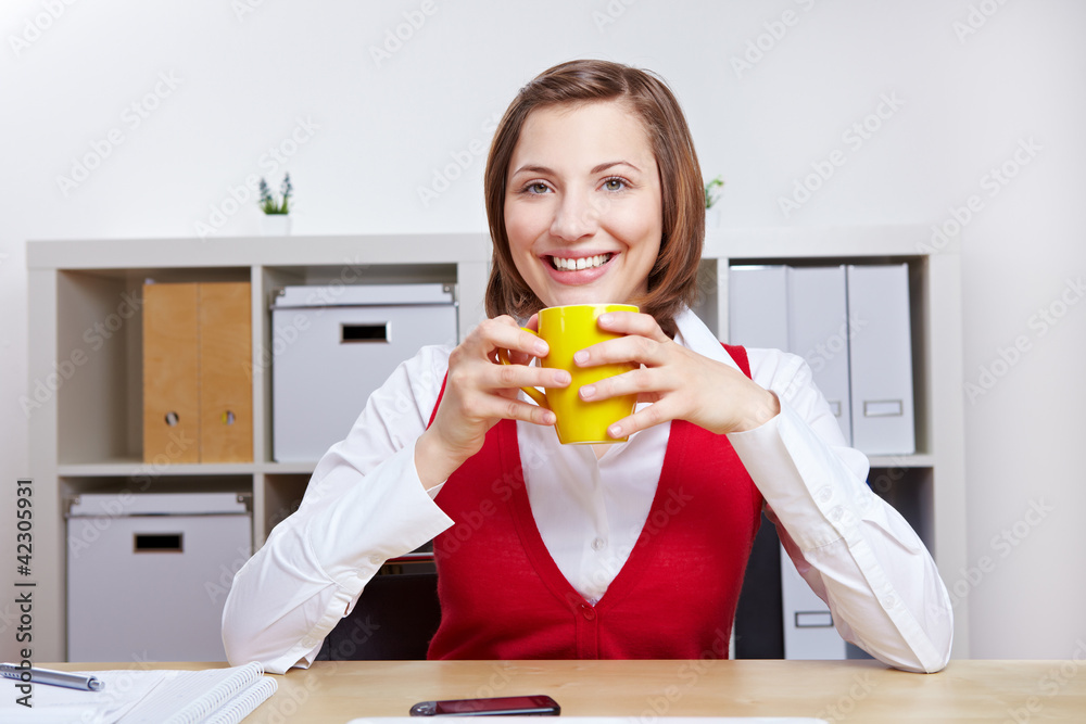 Lächelnde Frau trinkt Kaffee im Büro Stock Photo | Adobe Stock