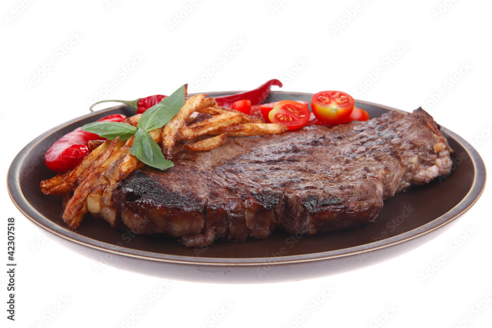 beef steak on dark plate with red hot chili pepper