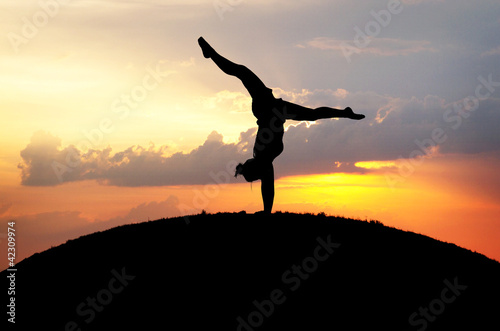 silhouette of female gymnast in sunset