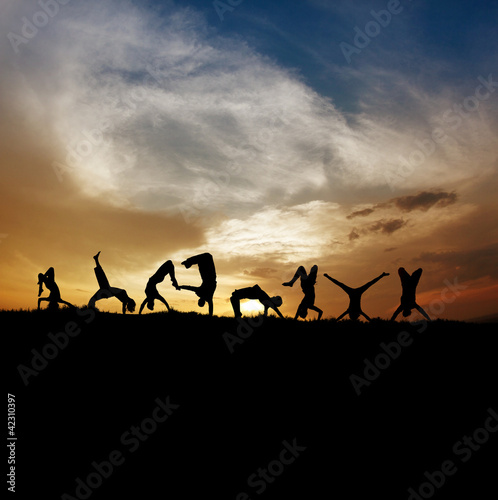 silhouette of gymnasts in sunset