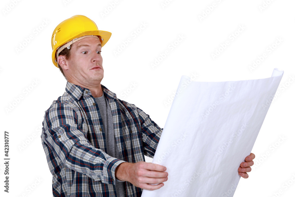 craftsman holding a blueprint and looking very surprised craftsman holding a blueprint and looking very surprised