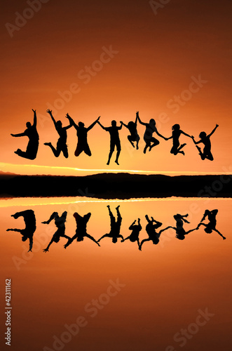 silhouette of teenagers jumping in sunset for fun