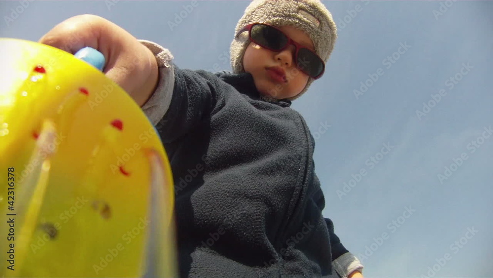 Little boy pouring water on camera lens