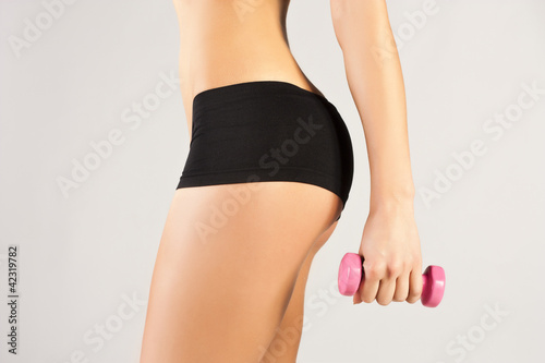 Nice sporty women body. Holding dumbbell