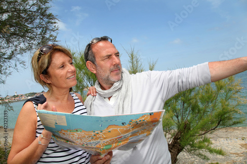 Senior couple on vacation looking at city map