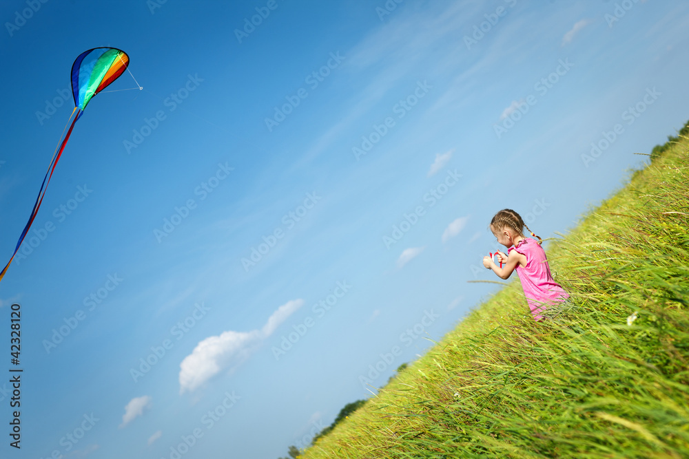 Back view of little girl flying a kite in the field Back view of little girl flying a kite in the field