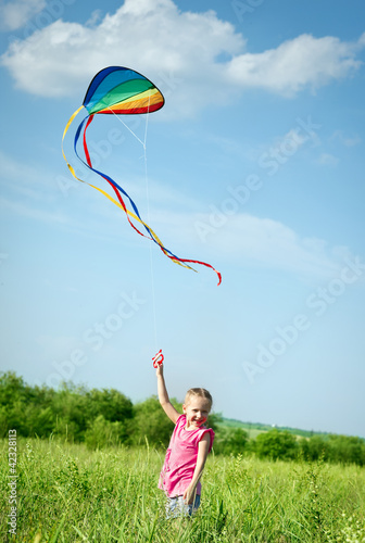Little girl flying a kite in the field