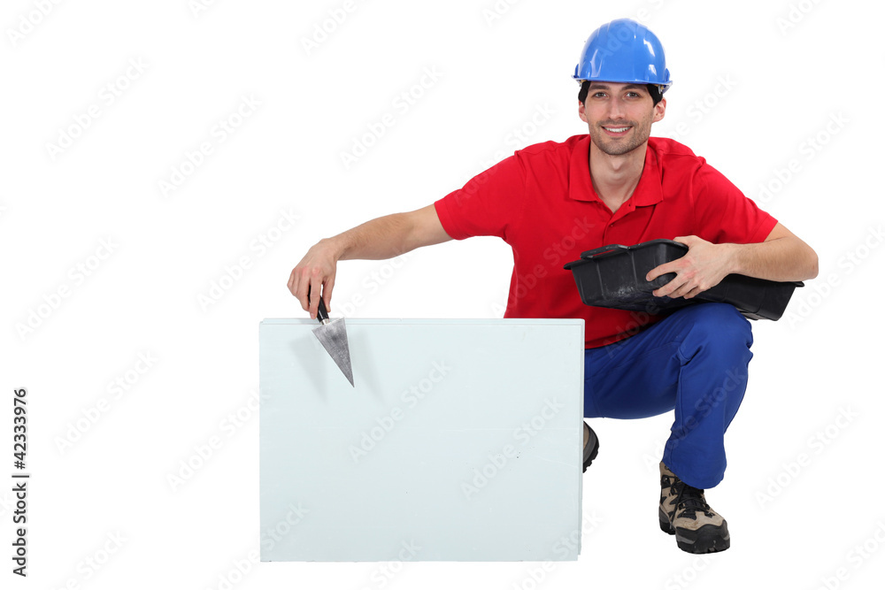 bricklayer hunkering down with trowel and copyspace bricklayer hunkering down with trowel and copyspace