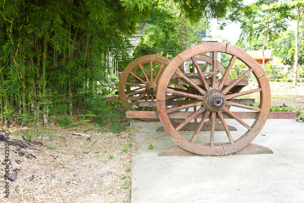Old wagon wheel near the bamboo grove.