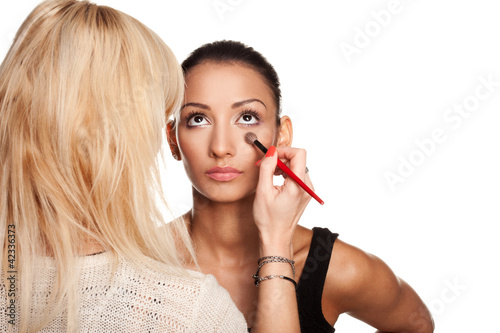 Photography Makeup artist applying makeup to her model