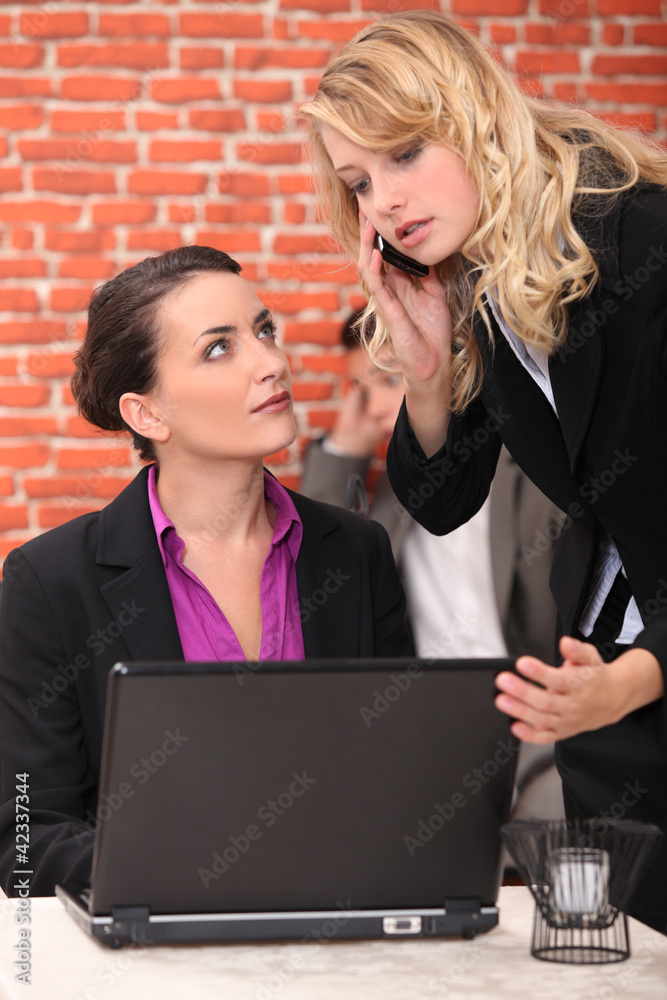 Restaurant owner using a laptop and taking a call Restaurant owner using a laptop and taking a call