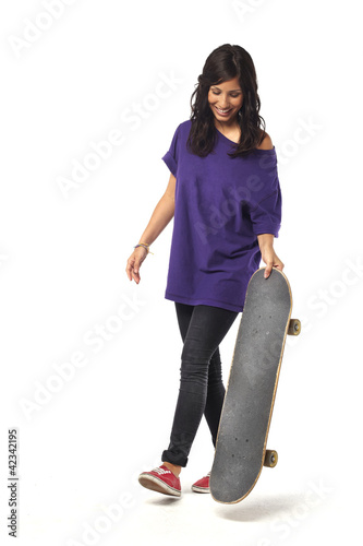 Happy young girl walking with skateboard isolated