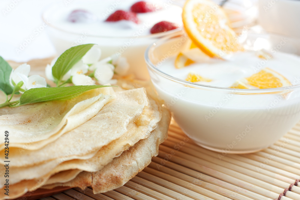 Fresh pancakes and orange yogurt Fresh pancakes and orange yogurt