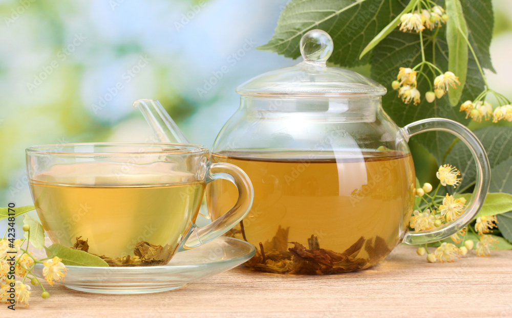 teapot and cup with linden tea and flowers teapot and cup with linden tea and flowers