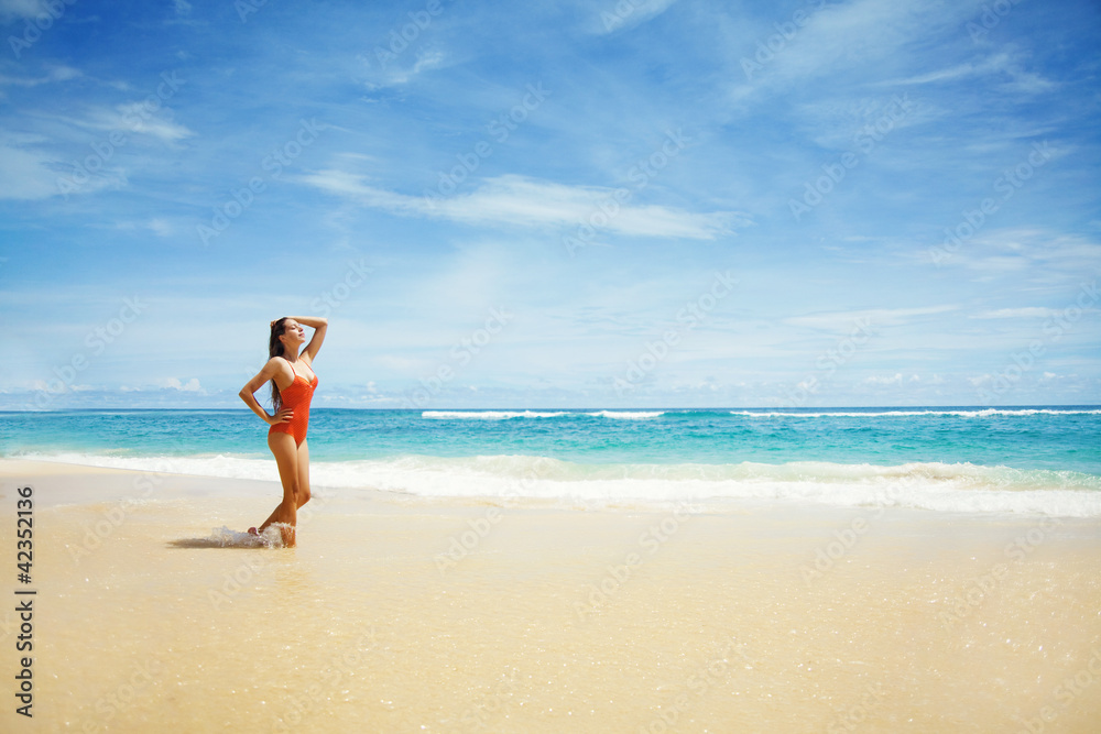 Young beautiful wet woman sitting on the sand near ocean, Bali, Young beautiful wet woman sitting on the sand near ocean, Bali,