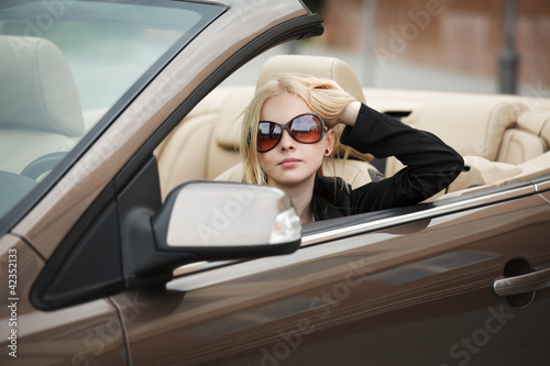 Young woman in a convertible car