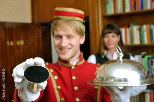 Hotelservice Page mit Tafel und Zimmermädchen photo