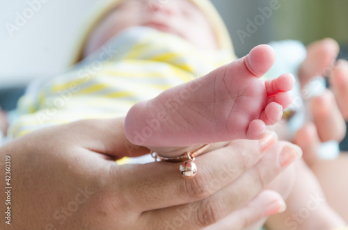 Newborn baby foot with mother's hand photo