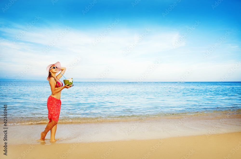 Young woman in pink swimsuit with coconut cocktail on the beach, Young woman in pink swimsuit with coconut cocktail on the beach,