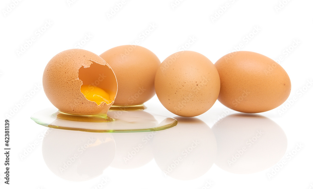 one broken and three whole eggs on a white background one broken and three whole eggs on a white background