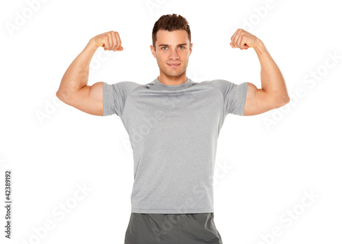 Fit and muscular man flexing his biceps on white