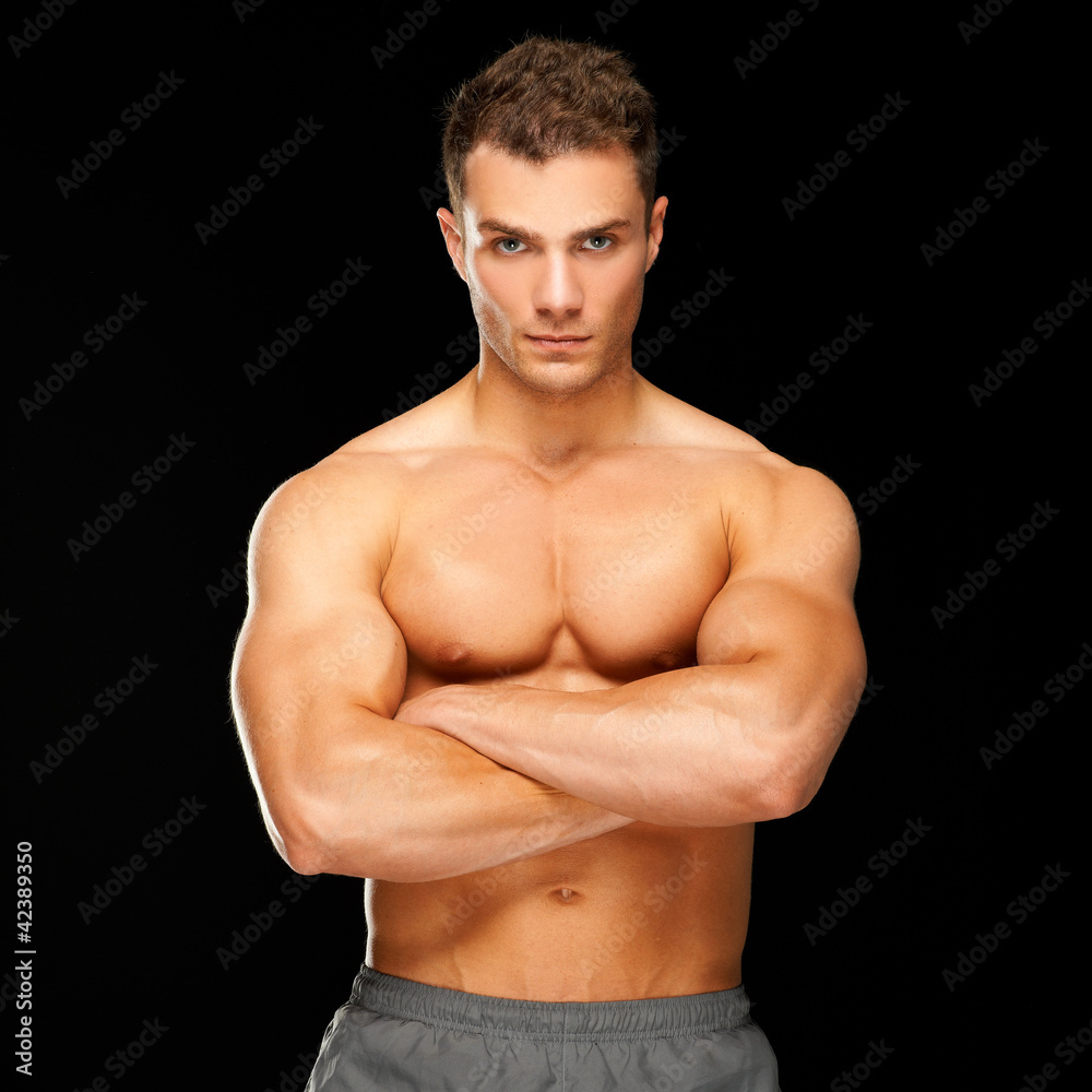 Fototapeta premium Handsome man with arms crossed looking his left on black