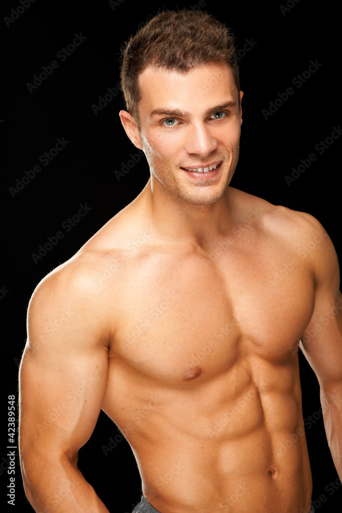 Handsome muscular young man isolated on black Handsome muscular young man isolated on black