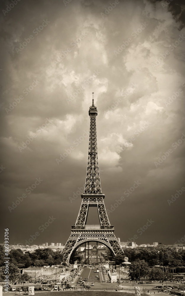 Naklejka premium Vintage styled image of Eiffel tower during daytime, sepia toned against the dramatic sky. Paris, France