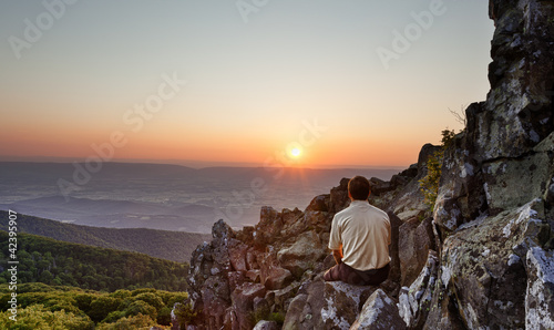 Senior man watches sunrise over blue ridge