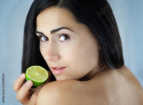 Piękna dziewczyna trzymająca zieloną cytrynę