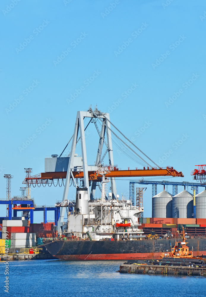 Container stack and ship under crane bridge