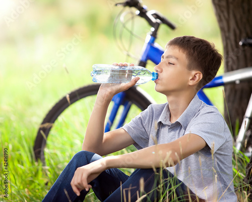 Tableau sur toile The cyclist in the park drinking clean water