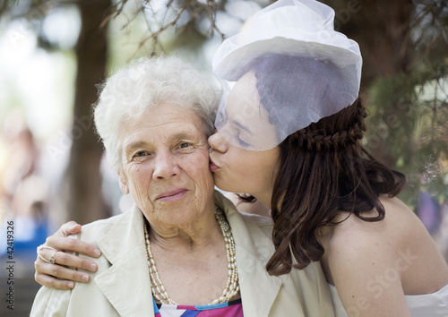 The young girl kisses the elderly woman