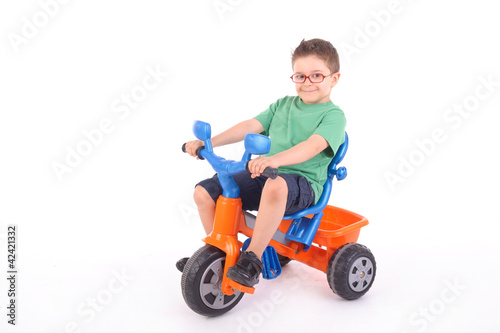 young boy riding his tricycle