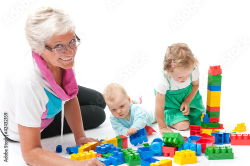 grandmother with grandchildren playing with blocks
