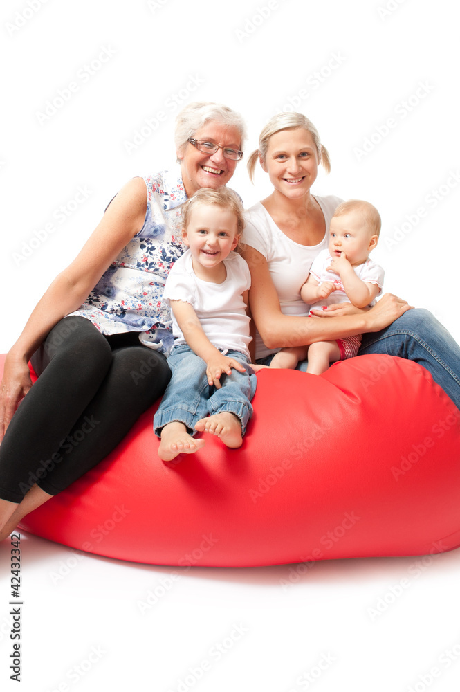 mother daughter and grandchildren on a red sofa mother daughter and grandchildren on a red sofa