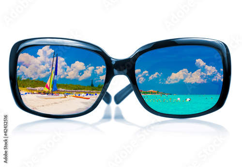 Sunglasses reflecting a tropical beach