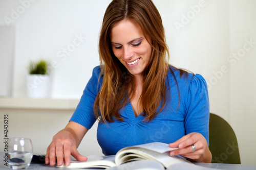 Blonde friendly young woman reading a book © pablocalvog