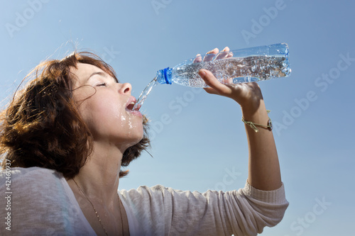 The girl pours water from a bottle