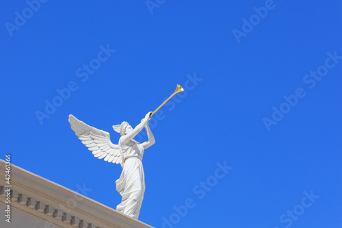 Foto A white statue of a winged troubadour