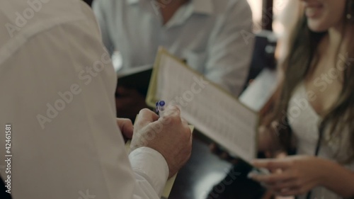 People ordering food and drink to waiter in restaurant