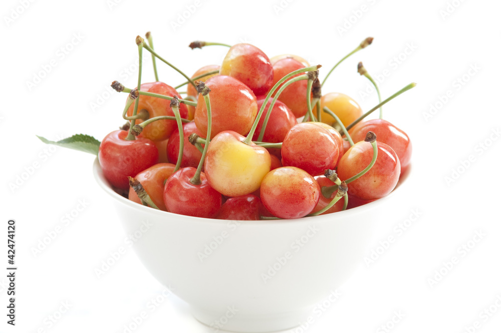 White bowl with sweet cherries isolated on white White bowl with sweet cherries isolated on white