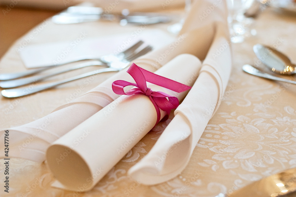 Banquet table setting with menu tied with pink ribbon Banquet table setting with menu tied with pink ribbon