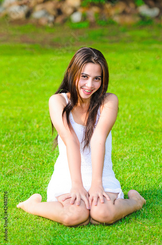 Beautiful healthy Young Woman sitting on the green grass © nuiiko