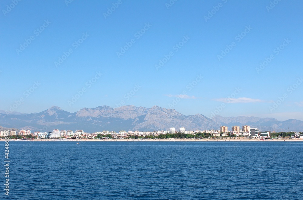 Sea and resort town of mountains in the background