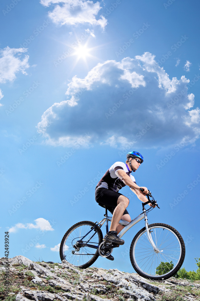 A bicyclist riding a mountain bike downhill style A bicyclist riding a mountain bike downhill style